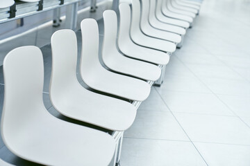 Empty white plastic chairs in the arena, a row of chairs with space to copy. High quality photo