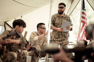 Soldiers in camouflage uniforms planning on operation in the camp