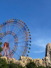 A ferris wheel with blue sky in theme park