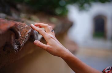 Female hand gently touches weathered tiles