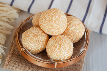 Onde-onde Sesame Seed Balls, filled with peeled green beans. Served on a wooden plate Close Up. Popular Indonesian Snacks
