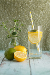 A glass of lemonade with lemon and lime.
