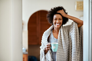 Black woman, portrait and morning coffee in home, blanket and comfortable in apartment. Female...
