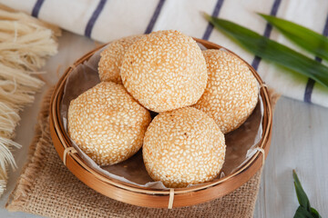 Onde-onde Sesame Seed Balls, filled with peeled green beans. Served on a wooden plate Close Up. Popular Indonesian Snacks
