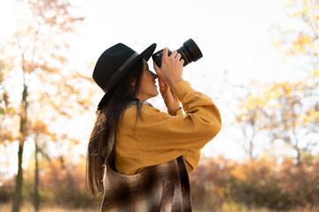 Professional woman photographer taking photo on camera outdoor, photography nature. Hobby and lifestyle