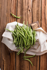 Fresh young beans pods. Old wooden background. Green string beans crop conception