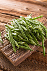 Fresh young beans pods. Old wooden background. Green string beans crop conception