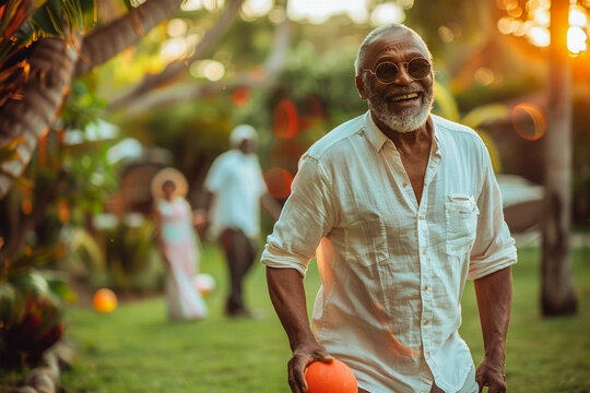 Old african american man playing ball with his grandchildren on the lawn at home, grandparent-grandchild interaction, backyard joy, outdoor play