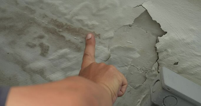Male finger is peeling paint on ceiling, Office building or house problem for house service. High definition shot at 4K, 50 fps video footage.