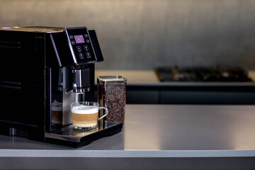 Modern coffee machine with glass cup of latte in kitchen