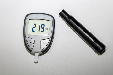 Blood sugar meter with test strips indicates high blood sugar levels.