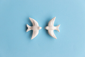 Two white swallows on blue background