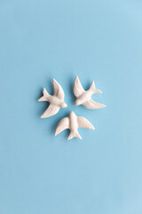 Three white swallows on blue background