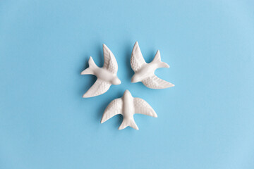 Three white swallows on blue background