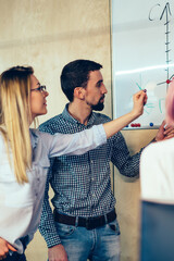 Young woman coach in eyeglasses together with successful students thinking on solution discussing...