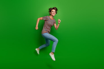 Full body profile portrait of energetic cheerful lady jump run empty space isolated on green color background