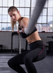 Fitness, woman and pull rope in gym for power workout, grip strength or intense cardio exercise....