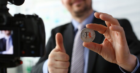Business trainer hold silver bitcoin in hand concept