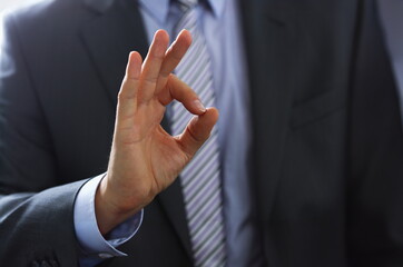 Male hand showing ok or confirm sign with thumb up during conference closeup. High level and quality product serious offer mediation solution happy client creative adviser participation concept