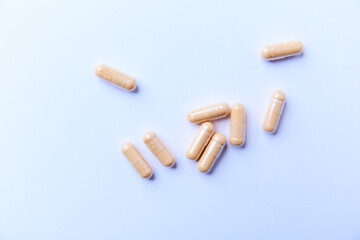 Lutein capsules. Dietary supplement on bright paper background. Soft focus. Top view. Close up. Copy space.
