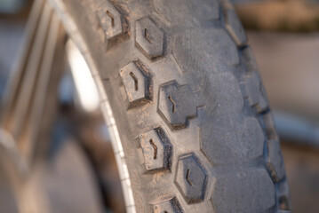 Close up of worn motorcycle tire. Concept of often used vehicles, two-wheeled transport, machinery details
