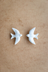 Two white swallows on neutral background