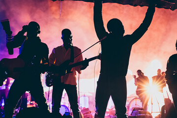 Concert. Festival rock together singing people group unrecognizable musicians silhouettes stage concert playing band music silhouette light song.