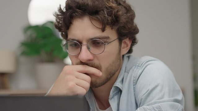 Thoughtful serious young caucasian man student writer sit at home office desk with laptop thinking of inspiration search problem solution ideas lost in thoughts concept dreaming looking away
