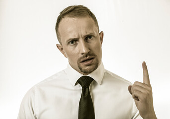 Handsome bearded man in casual clothes pointing to side while looking at camera. Strong face. Finger