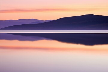 Fototapeta premium This serene landscape captures the enchanting moment of sunset with smooth transitions of purple and orange hues painting the sky