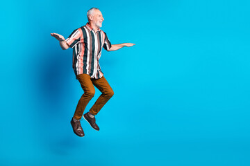 Fototapeta premium Photo of cheerful glad senior man wear striped stylish clothes look blank space isolated on blue color background