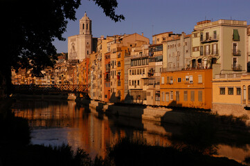 Fototapeta na wymiar The Onyar River flows peacefully at the foot of the old city of Girona (Spain)