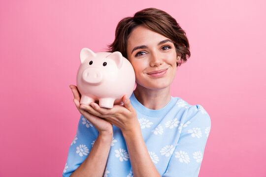 Photo of nice positive lady hands hold showing money savings pig bank isolated on pink color background