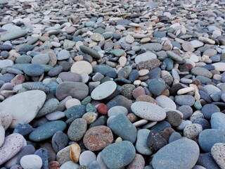 Perspective of rounded Sea Pebble stones and rocks on beach as natural abstract pebble texture or background. Random small pebble stones. Close up colorful Pebble stones or gravel on Batumi coast.