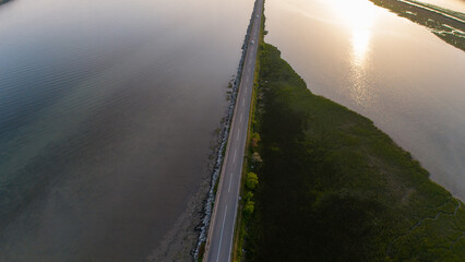 Aerial photo of road across the lagoon in the light of the setting sun.