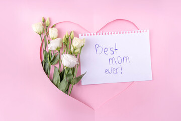 Mother's day international holiday greeting card , on pink background with flowers. Cut out heart...