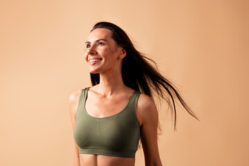 Photo of smiling joyful girl with flying hair look empty space beauty ads isolated pastel color background