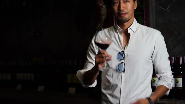 Japanese man, tourist, wine tasting, holding wine glass, tasting red wine, happy drinking wine in wine factory