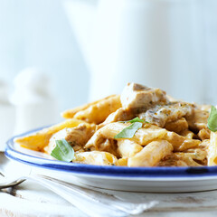 Penne Pasta baked with Meat on bright wooden Background. Close up.	