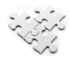 Fototapeta premium Scattered white puzzle pieces on the table, isolated on a clean white background. 