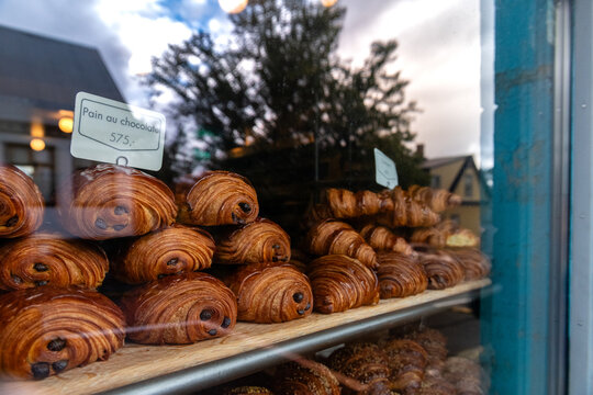 A window display of pastries with a sign that says "Patisserie au Chocolat"