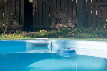 A pool with a blue and white chlorine buoy in it