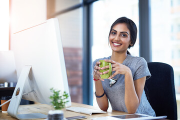 Coffee cup, computer and portrait of creative Indian woman in office with confidence, relax or...