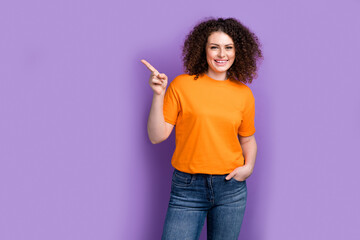 Photo of cheerful positive lady dressed orange t-shirt showing finger empty space isolated violet...