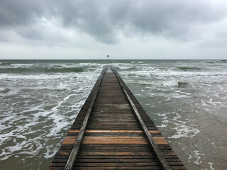 A boardwalk under a stormy grey sky