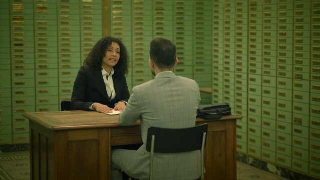 Sales Agent Talking to Customer Inside Safe Vault Room Explaining Deposit