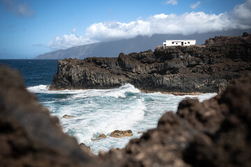 Fototapeta na wymiar Isolated white house on cliff above sea in Pozo de la Salud, El Hierro, Canary Islands, Spain