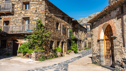 Village church with stone houses around next to the mountain, Castilla la Mancha, Spain.