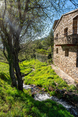 Streams of clear water that circulate next to the stone houses of the mountains, Castilla la Mancha.