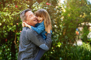 Fototapeta premium Father, girl and hug in outdoor nature, laugh and play together for bonding in backyard. Daddy, daughter and embrace in park for love and care in garden, forest and support or security in parenthood